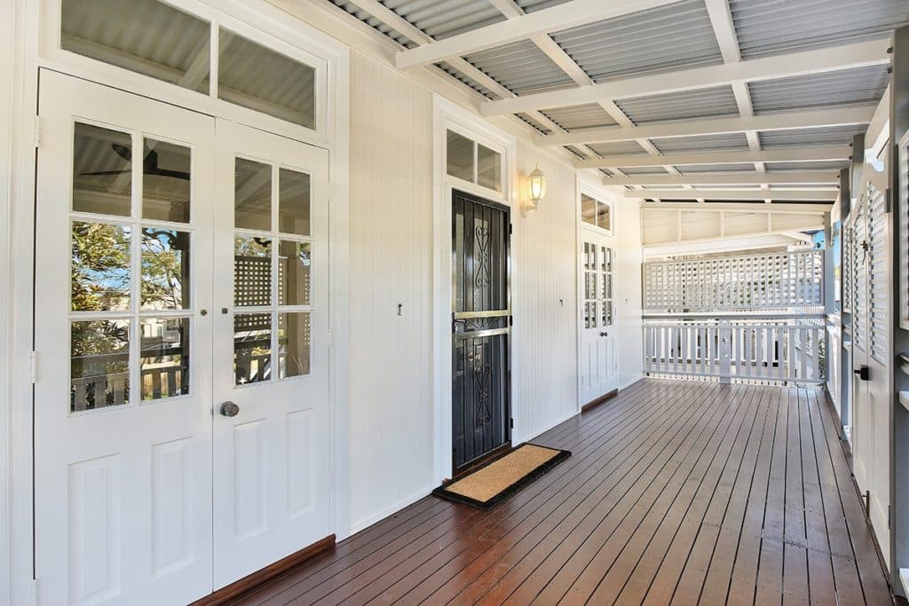 Freshly painted Queenslander verandah in Bulimba with French doors, fanlights, VJ walls, lattice screens and timber decking